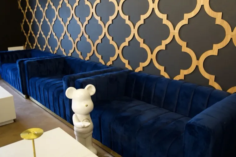 Navy velvet booths against a gold patterned wall