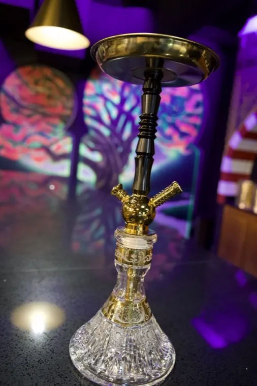 A crystal-base hookah under warm neon