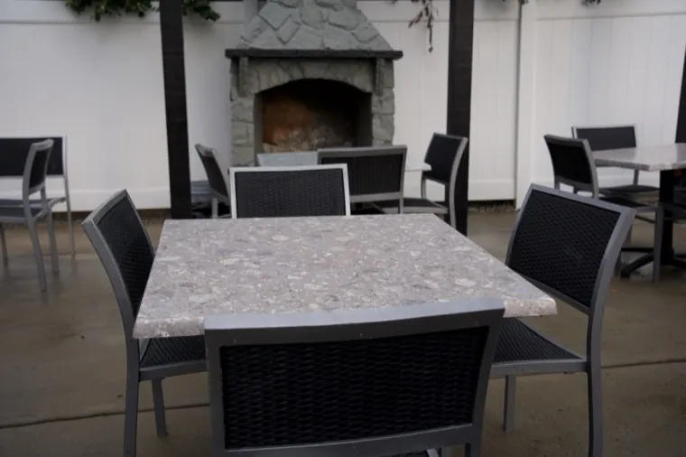 Outdoor patio with a stone fireplace and tables